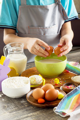 Chef boy cooking on a Easter kitchen table and cooking dough. Food background for children.