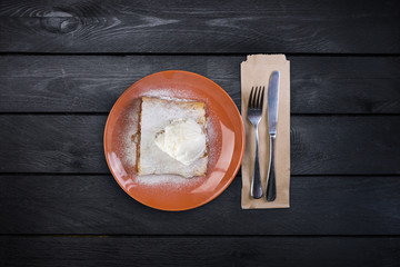 Strudel with an apple , served on the ceramic plate with the ice cream and the cutlery.