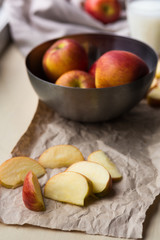 Preparation of whole and sliced apples and cake ingredients on craft papers