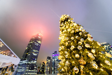 Christmas tree at night with New York City skyscrapers on background