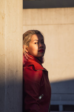 Portrait of young woman in red jacket standing outdoors
