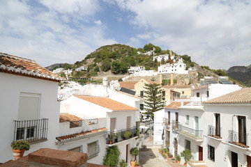 Fototapeta na wymiar Small alley of a mediterranean village at the coast of Spain with white houses and a green landscape