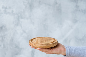Mans hand with wooden tray mockup. Free space for advertising and marketing.