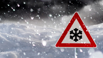 Verkehrsschild warnt vor Schneefall und Straßenglätte