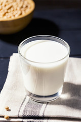 Healthy glass of soymilk and soyseeds in a bowl.