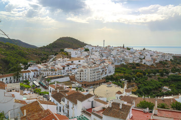 Naklejka premium Unique view of the rooftops in Frigiliana with white houses the green mountain and the sea at the horizon