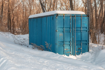 snow covered blue container in winter outdoors