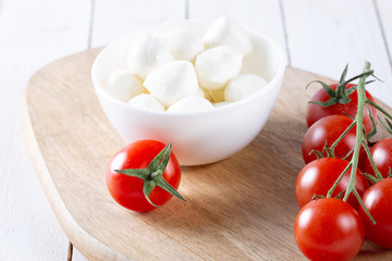 Fresh cherry tomatoes and mozzarella on white background