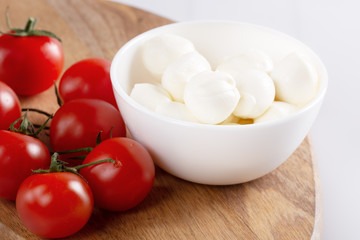 Fresh cherry tomatoes and mozzarella on white background