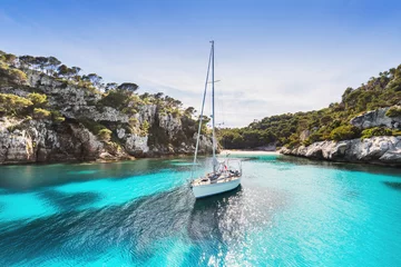 Fotobehang Mooi strand met zeilbootjacht, Cala Macarelleta, eiland Menorca, Spanje. Yachting, reizen en actieve levensstijl concept © kite_rin