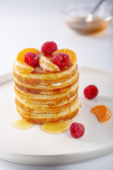Fresh homemade pancakes with raspberry fruits and honey