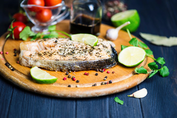 red fish salmon baked with spices and lemon on a wooden board