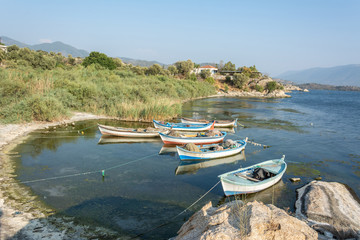 Fototapeta na wymiar Fishing boats moored along the shore of Lake Bafa in Turkey.