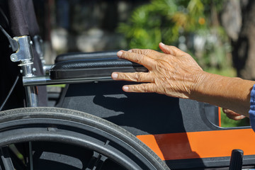 Obraz premium Elderly hands on a wheelchair.