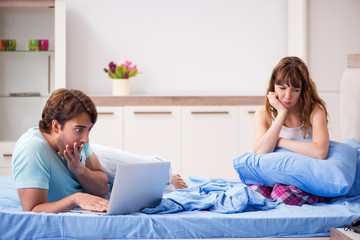 Young couple with laptop in the bedroom