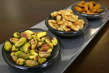 Bowls with three different nut varieties, including: walnuts, pistachios and almonds