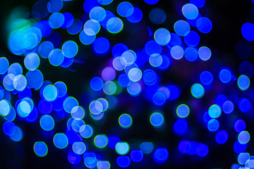 Beautiful blue bokeh abstract light background. Wonderful Defocused abstract blue christmas background. Abstract christmas lights as background in the night with noise grain and poor light.