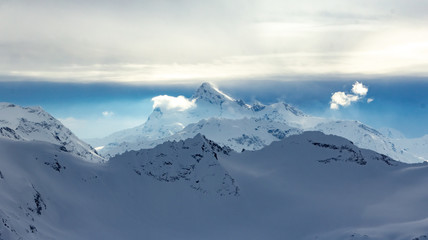 Fototapeta na wymiar Snowy Mountains in blue and white sky