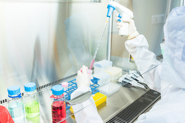 A scientist in sterile coverall gown Doing biological research in clean environmental. Cleanroom...