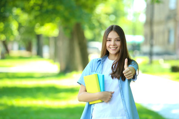Fototapeta premium Cute girl with books in the park