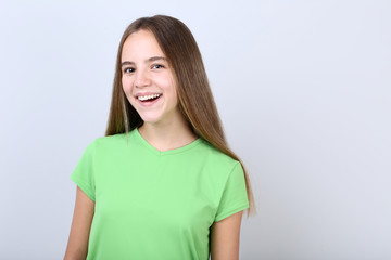 Fototapeta premium Young girl wearing t-shirt on grey background