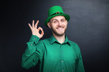 St. Patrick's Day. Young man wearing green hat on black background