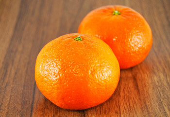 Beautiful juicy tangerine on wooden table close up