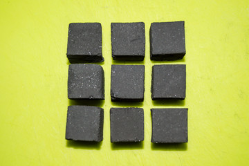 coconut coal cubes on bright green background