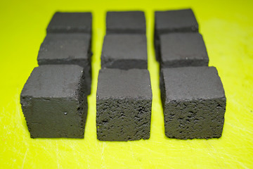 coconut coal cubes on bright green background