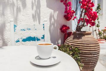 Traditional greek coffee in a cafe with beautiful mediterranean street on the background