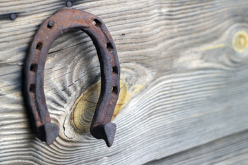 Rusty old vintage weathered horseshoe on wooden background.
