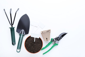 Garden tools with ground in pot on white background