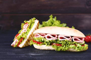 Tasty sandwiches on black wooden table
