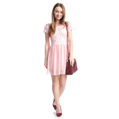 Woman in pink dress and red high heel shoes, red leather handbag goes walking on white background isolation
