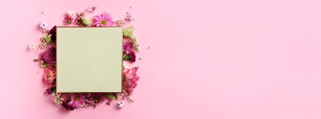 Frame of pink flowers over punchy pastel background. Valentines day, Woman day concept. Spring or summer banner with copy space