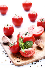 Ripe tomatoes with basil leafs and garlic on wooden table