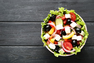 Vegetable salad in bowl on black wooden table