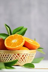 Fresh oranges fruit in basket on white table background.