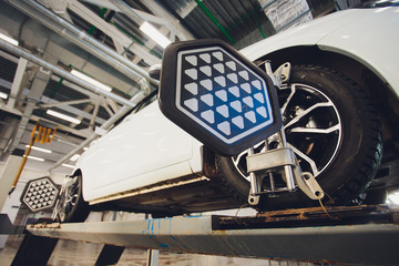 A Car on the Car Steering Wheel Balancer and Calibrate with laser reflector attach on each tire to...
