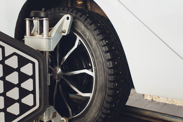A Car on the Car Steering Wheel Balancer and Calibrate with laser reflector attach on each tire to...