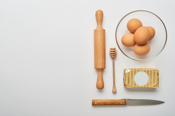 flat lay with wooden cooking utensils and raw bakery ingredients on grey background