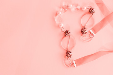 Female coral beads on a pink background. Empty space for text