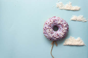 Concept purple donuts on a blue background with clouds minimalism