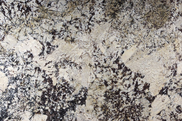 Beige granite with dark patterns in the form of needles on the surface, called Delicatus Cream