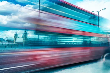 Rolgordijnen London Red Bus versnelt in Londen. Wazig zicht met de skyline van de stad op de achtergrond © jovannig