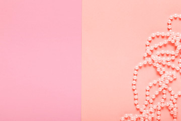 white pearl necklace on pastel coral and pink paper background