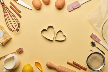 Fototapeta na wymiar top view of bakery ingredients and cooking utensils around heart shaped dough molds