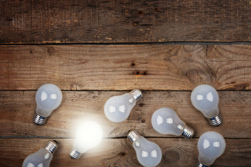 Vintage bulbs on wooden background - idea, innovation, teamwork and leadership concept. Space for text