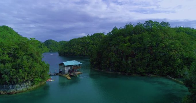 Aerial view flying over the beautiful and tropical green mountains Sugba Lagoon in Siargao, Philippines