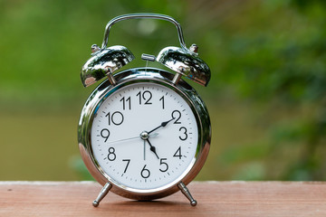 Retro alarm clock  on wood table with bokeh background